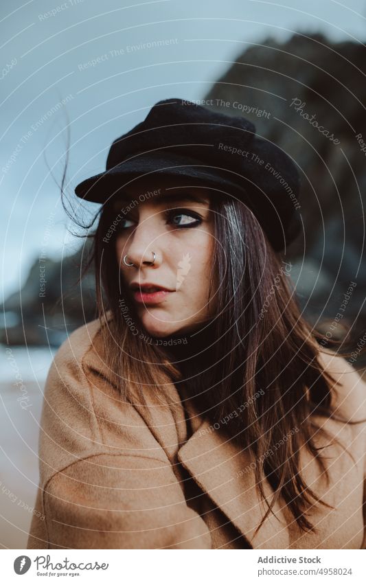 Stylish female on windy day near sea woman shore looking away style young lifestyle leisure rest relax coast trendy harmony calm tranquil serene peaceful