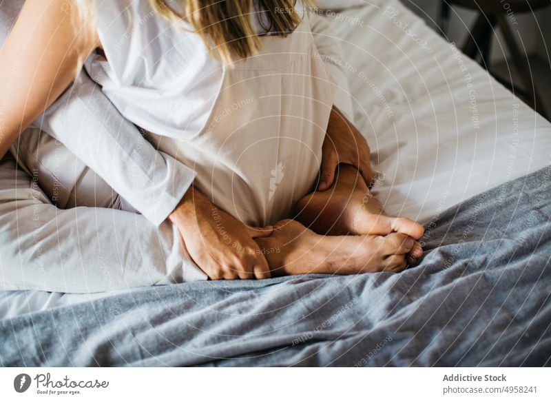 Anonymous couple cuddling on comfortable bed in apartment tender affection relationship cuddle relax embrace love hug bedroom girlfriend boyfriend sit bonding