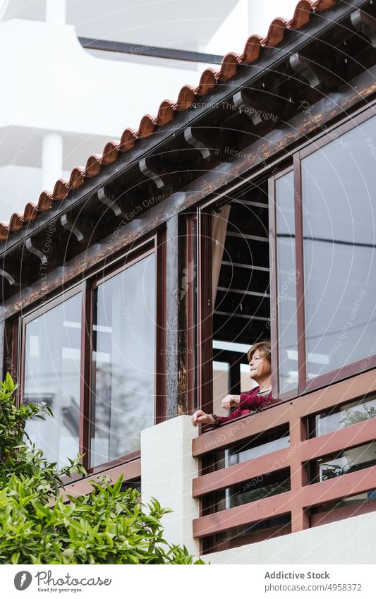 Senior lady resting on balcony woman window home dreamy retire casual elderly think female lifestyle relax serene pensive aged peaceful tranquil calm thoughtful