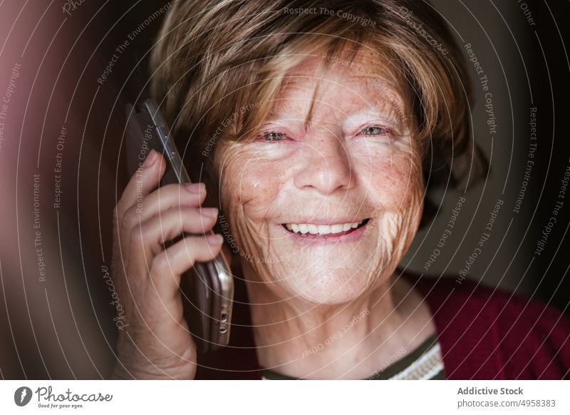 Senior woman making call at home speak smartphone retire wrinkle rest connection listen female elderly mature mobile senior conversation aged device gadget cozy