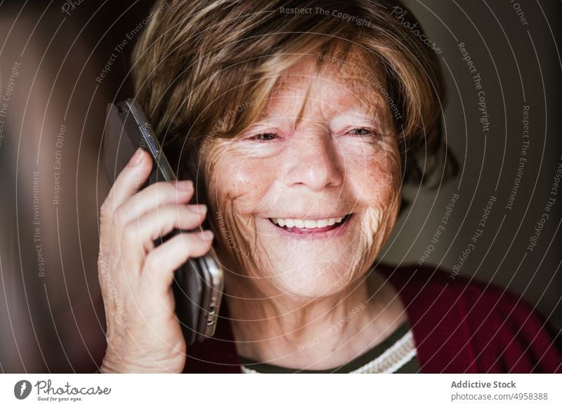 Senior woman making call at home speak smartphone retire wrinkle rest connection listen female elderly mature mobile senior conversation aged device gadget cozy