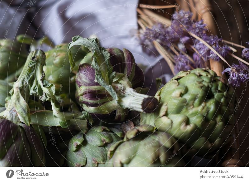 Green artichokes laid in basket green wicker bunch flower little purple fresh napkin decoration vegetable food healthy ripe vegetarian agriculture organic diet