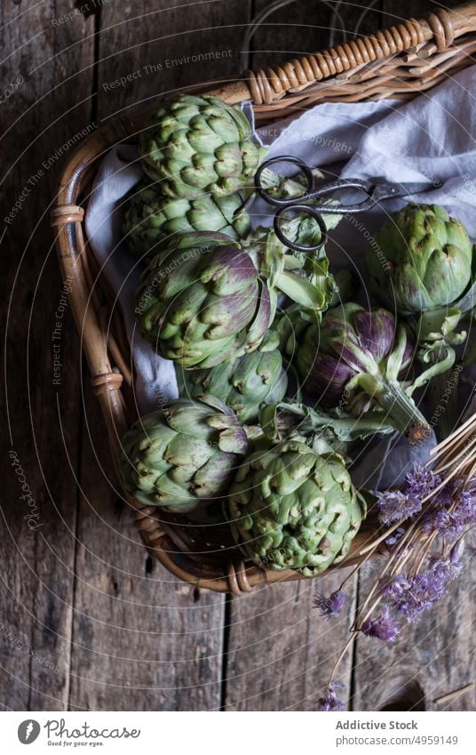 Green artichokes laid in basket green wicker bunch flower little purple fresh napkin decoration vegetable food healthy ripe vegetarian agriculture organic diet