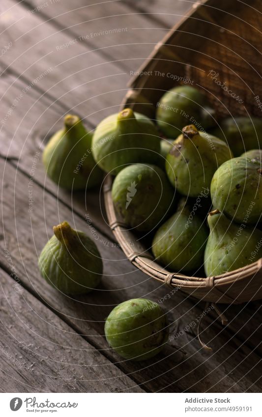 Wicker bowl with green figs full fruit fresh ingredient health heap vitamin vibrant nutrition natural food juicy exotic sweet table vegetarian raw vegan utensil