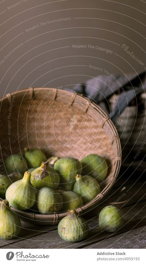 Wicker bowl with green figs full fruit fresh ingredient health heap vitamin vibrant nutrition natural food juicy exotic sweet table vegetarian raw vegan utensil