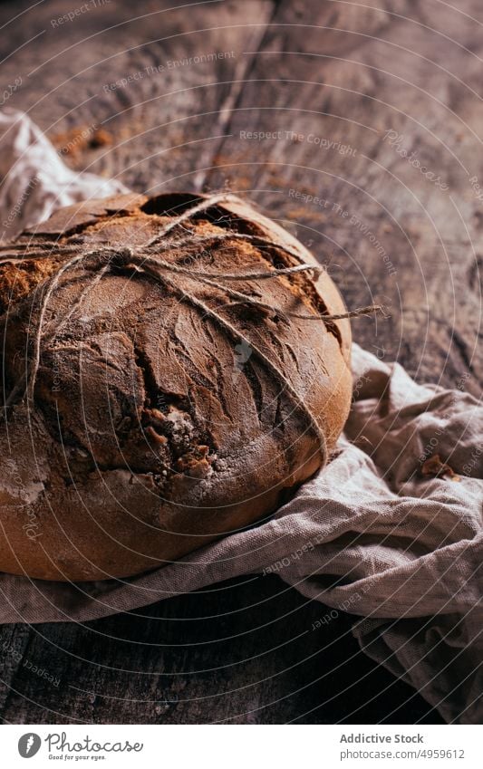 Appetizing homemade bread placed on wooden cutting board with napkin food baked bakery rustic fresh meal delicious kitchen nutrition table cuisine organic yummy