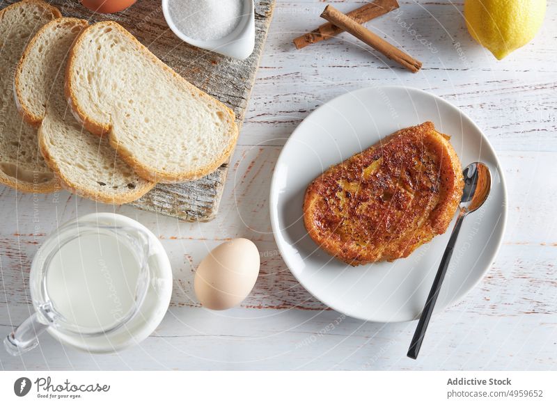 Tasty torrija bread served on table with fresh ingredients in kitchen milk egg sugar cinnamon lemon breakfast food appetizing cutting board delicious toast