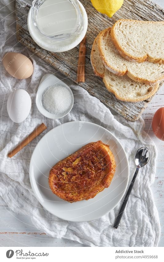 Tasty torrija bread served on table with fresh ingredients in kitchen milk egg sugar cinnamon lemon breakfast food appetizing cutting board delicious toast