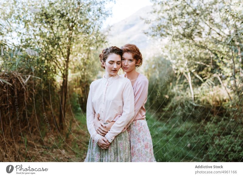 Romantic Women Couple Posing In Natural Setting beautiful beauty best friends blooming caucasian classic clothing cool couple cute dress elegant embrace face