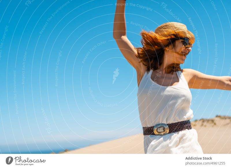 Smiling woman in dress walking on sandy beach in summer vacation seashore holiday enjoy sunhat female cabo de gata almeria cheerful spain smile natural park