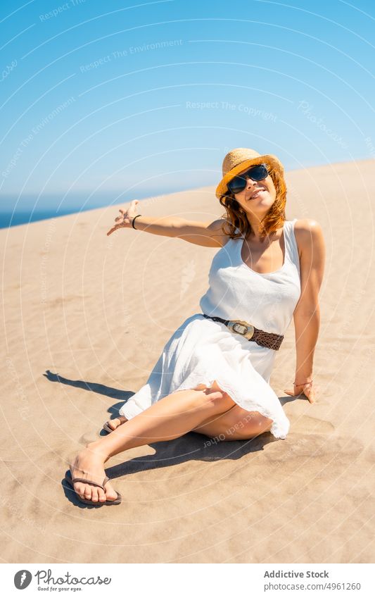 Smiling woman in dress on sandy beach in summer vacation seashore holiday smile enjoy sunhat female cabo de gata almeria spain natural park cheerful happy