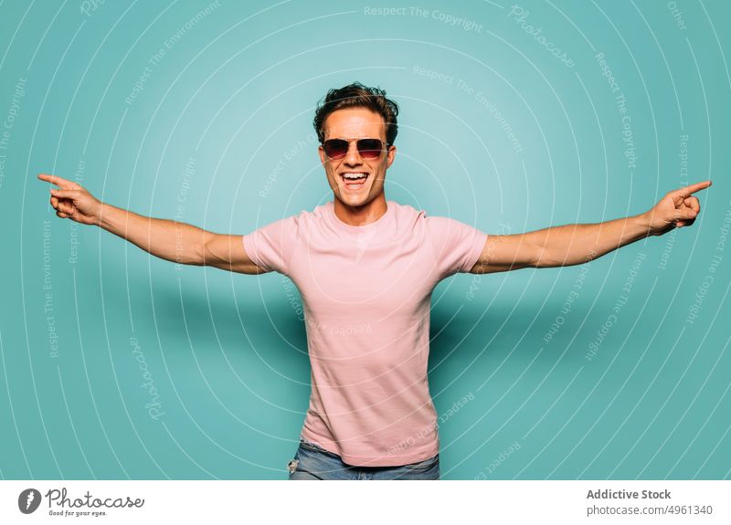 Content masculine model in sunglasses on blue background fashion style content macho friendly man portrait accessory contemporary happy toothy smile