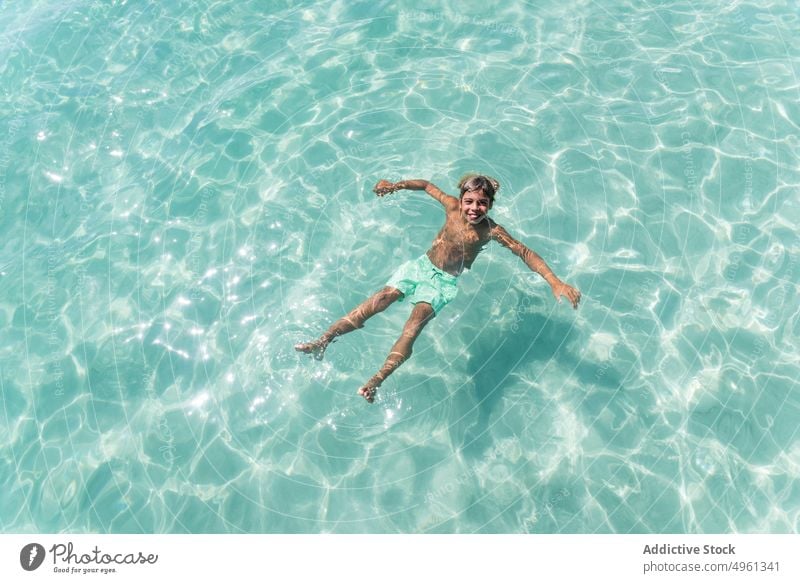 Happy teen boy swimming in sea summer vacation teenage cheerful holiday enjoy smile carefree optimist delight sunny water clear transparent aqua translucent