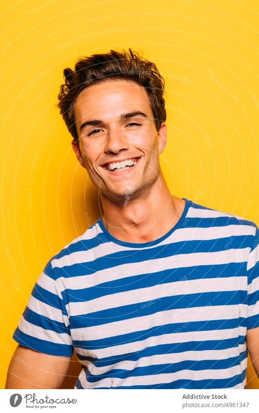 Stylish model with modern haircut on yellow background man fashion trendy soap bubble rebel stripe colorful portrait having fun transparent creative design cool