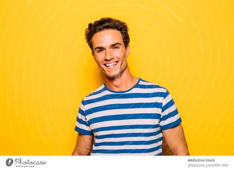 Stylish model with modern haircut on yellow background man fashion trendy soap bubble rebel stripe colorful portrait having fun transparent creative design cool