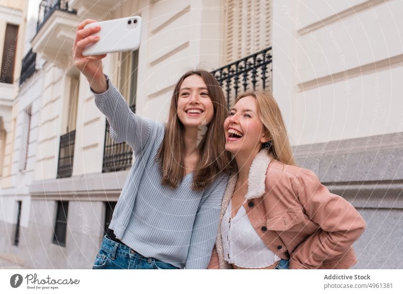 Women taking self shot in city women selfie best friend smartphone friendship self portrait moment female madrid spain weekend together street content cellphone