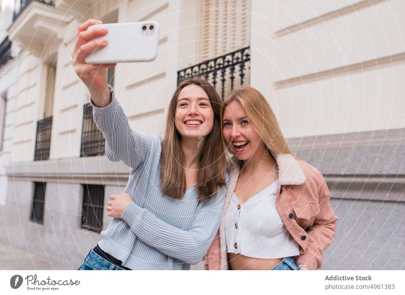 Women taking self shot in city women selfie best friend smartphone friendship self portrait moment female madrid spain weekend together street content cellphone