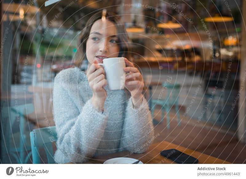 Woman drinking coffee in cafe woman dreamy thoughtful window cafeteria beverage enjoy female delicious tasty sit table tranquil serene cup cozy fresh young