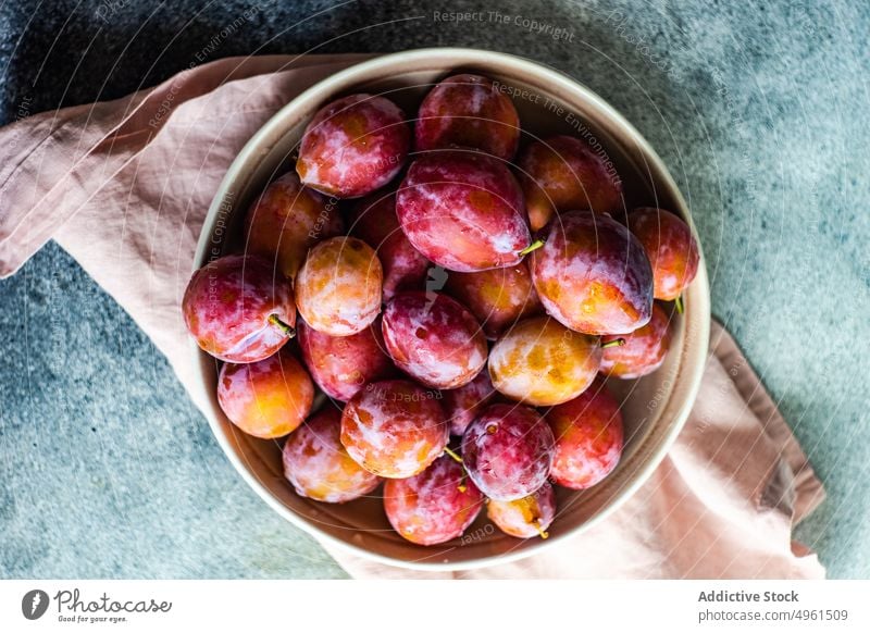 Organic ripe plums in the bowl ceramic dessert eat food fresh fruit harvest healthy organic pink plant based purple seasonal slice summer vitamin natural table