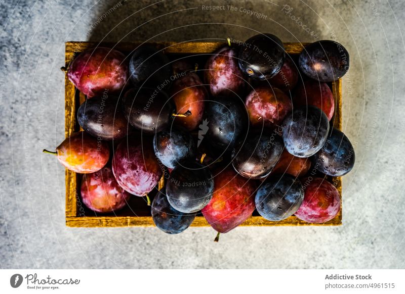 Organic ripe plums in wooden box crate dessert eat food fresh fruit harvest healthy organic pink black plant based purple seasonal slice summer vitamin natural