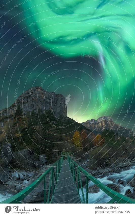 Amazing polar lights in dark sky over bridge in mountains northern landscape aurora borealis night river nature norway lofoten islands picturesque scenery green