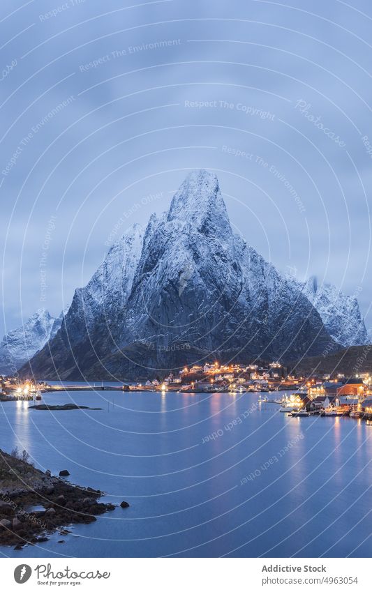 Coastal town near scenic rocky mountains in evening in Norway sea range landscape house fjord village residential highland ridge spectacular fog lofoten norway