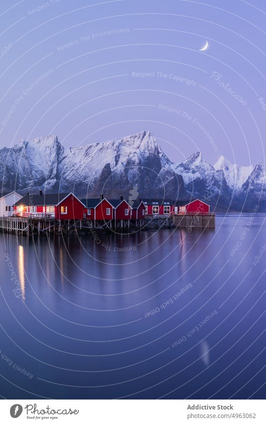 Residential houses near sea and mountains under twilight sky landscape town fjord snow residential winter cottage nature rocky village lofoten norway settlement