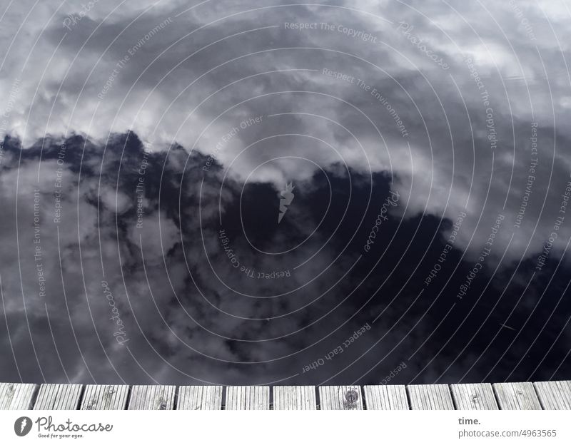 deeply relaxed over the edge of the jetty Lake Water Clouds Footbridge wooden planks investor Sky somber Weather Reflection Landscape Lakeside Nature Wet Damp