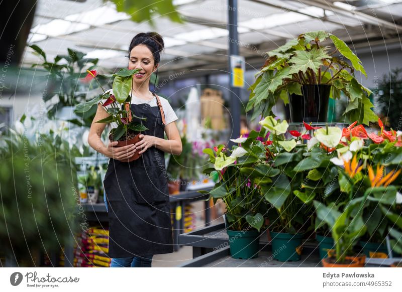 Shot of a young woman working with plants in a garden centre plant nursery smiling positivity nature gardening cultivate growth hobby freshness growing flora