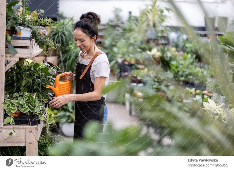 Shot of a young woman working with plants in a garden centre plant nursery smiling positivity nature gardening cultivate growth hobby freshness growing flora