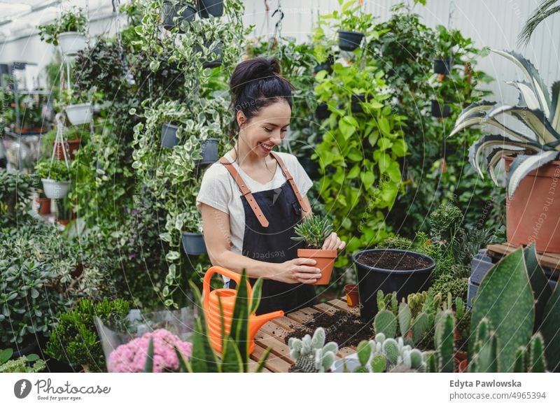 Florist at the flower shop, taking care of plants plant nursery smiling positivity nature garden gardening cultivate growth hobby freshness growing flora green