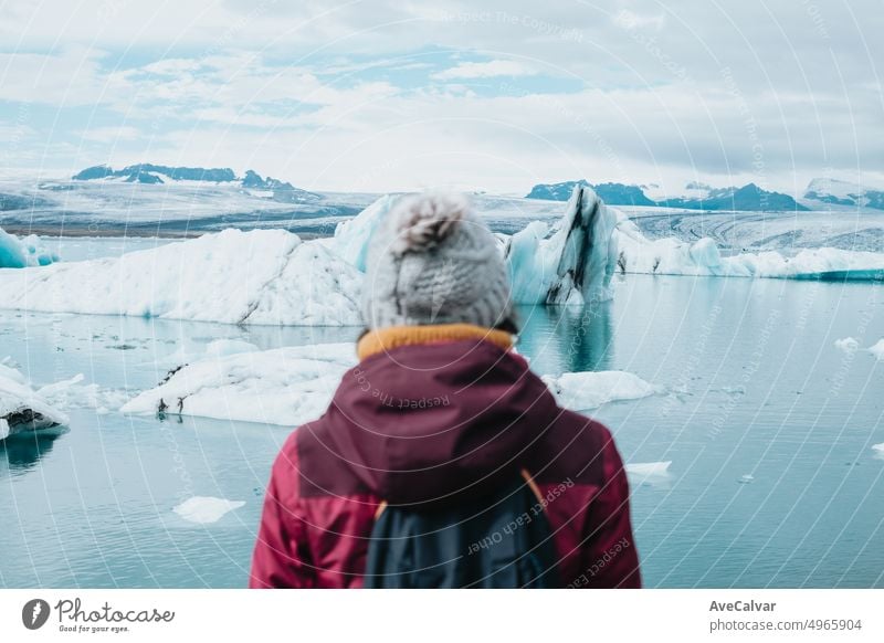 A female tourist is standing in front of jokulsarlon glacial lagoon. Ice beach, Breidamerkursandur, Diamond Beach. Traveling and exploring the world as a digital nomad.road trip style.Copy space .