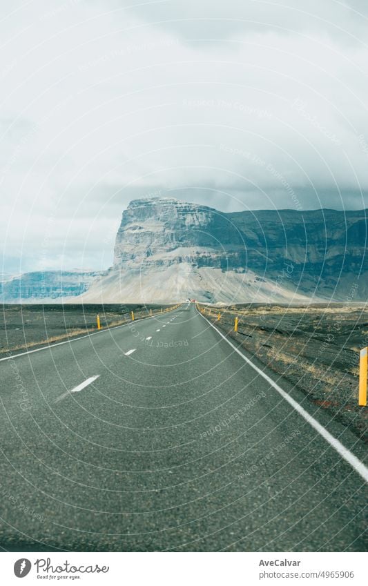 Massive mountain with canyon on Iceland, end of an infinite road. View from the road during a trip through Icelandic wild areas. Boho backpacking traveling style, nature background concept. Colorful