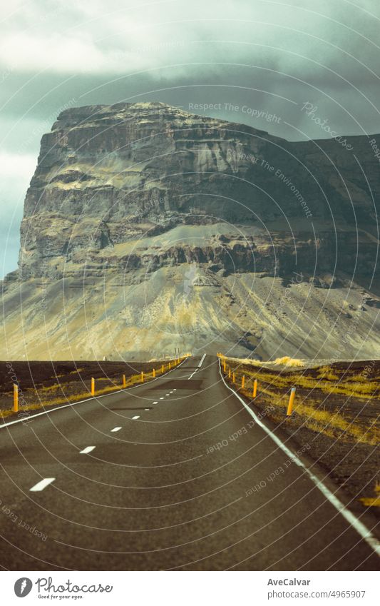 Massive mountain with canyon on Iceland, end of an infinite road. View from the road during a trip through Icelandic wild areas. Boho backpacking traveling style, nature background concept. Colorful