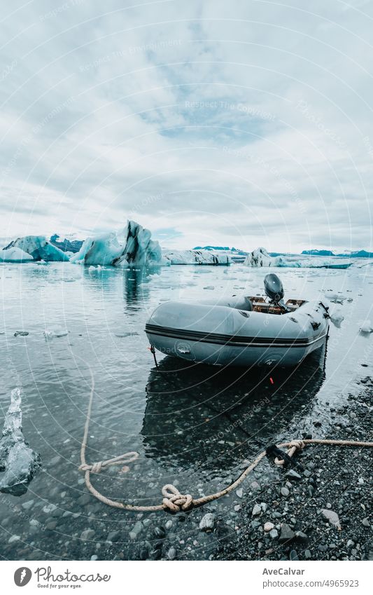 A rescue boat on Jokulsarlon glacier ice closeup, Iceland nature landscape view. Ice blocks from at Jökulsárlón glacier lagoon, Vatnajökull National Park, Iceland, near Route 1 / Ring Road