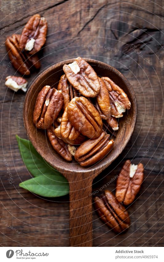 Shelled Pecan nuts in a wooden spoon bowl pecan dry fruit nutrition ingredient healthy cooking baking food omega3 shelled vegan vegetarian fat spoonful brown