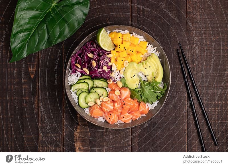 Delicious poke bowl with assorted veggies rice and salmon avocado mango asian food chopstick healthy food cucumber dish cuisine fish meal delicious tradition