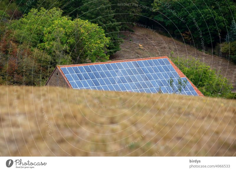 Old building behind a hill with a full-surface photovoltaic system on the roof. photovoltaics Solar cells Renewable energy Solar Energy Solar Power