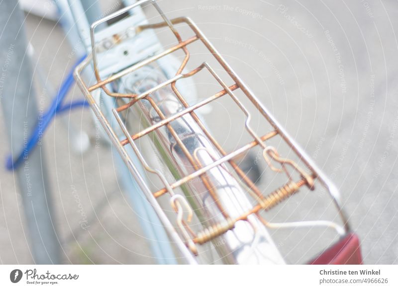 Detail of bicycle with rusted luggage rack secured to a post with cable lock Bicycle Old bicycle rack Authentic Glittering Perspective Exterior shot