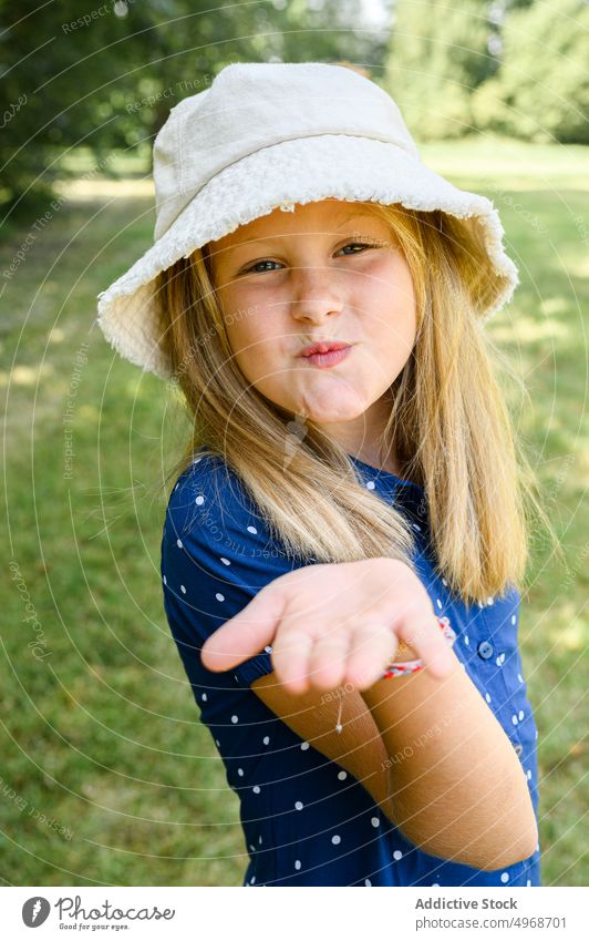 Cute girl blowing kiss in summer air kiss field love weekend nature happy cute countryside meadow kid blond daytime positive little season headwear bucket hat