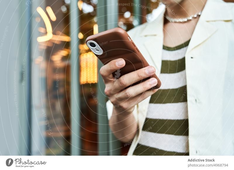 Young man using smartphone on street texting style glass wall urban online modern male young text message mobile browsing building gadget lifestyle cellphone