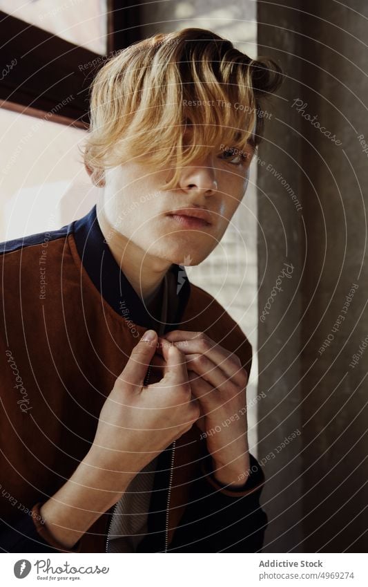 Young man sitting near window in old room windowsill hall handsome relaxed urban trendy cool glamour stylish model young male guy attractive elegance confidence