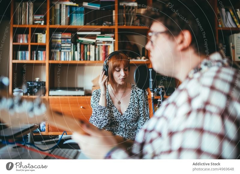 Musician playing guitar against singer at home musician rehearsal melody smile woman show guitarist instrument musical point up attention indicate mic