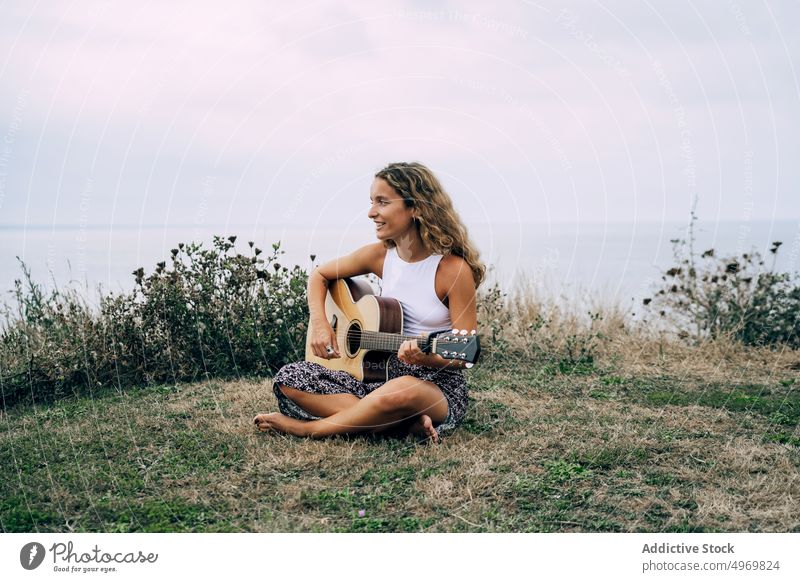 Woman playing guitar in field with dry vegetation music woman romantic young instrument cheerful female musical fun vacation fashion holiday casual summer