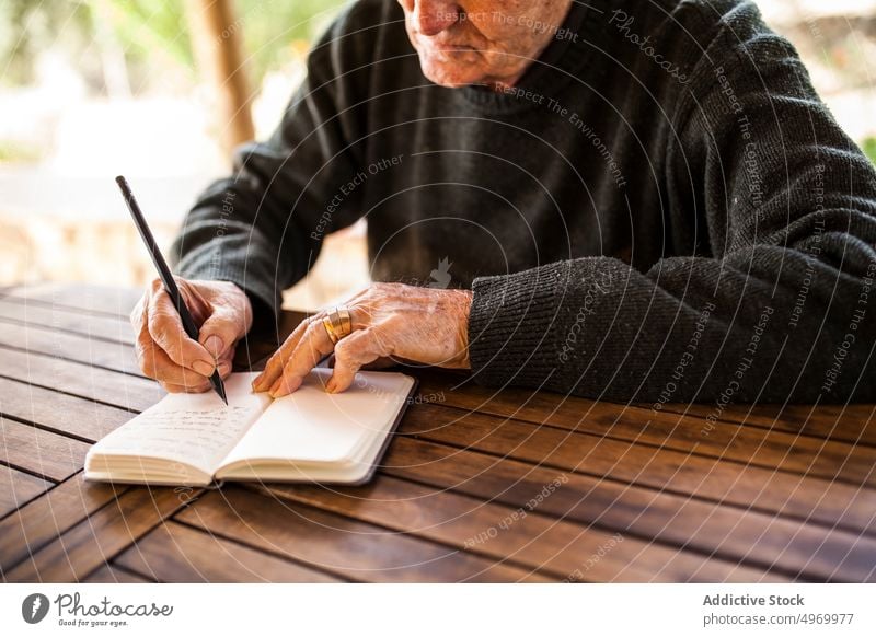 elderly man writing in his notebook lifestyle smart expression construction male business grey home person indoors document adult years write owner accountant