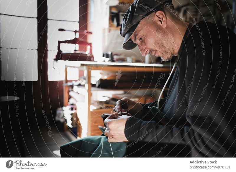 Man sewing textile in atelier tailor needle workshop man leather dickey workplace fashion clothing studio dressmaker design hat craft fabric industry handicraft