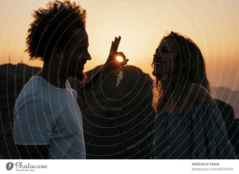 Young couple having fun in highland during sunrise ok sunset sky sunbeam travel okay boyfriend girlfriend gesture finger romantic cheerful idyllic joy sundown