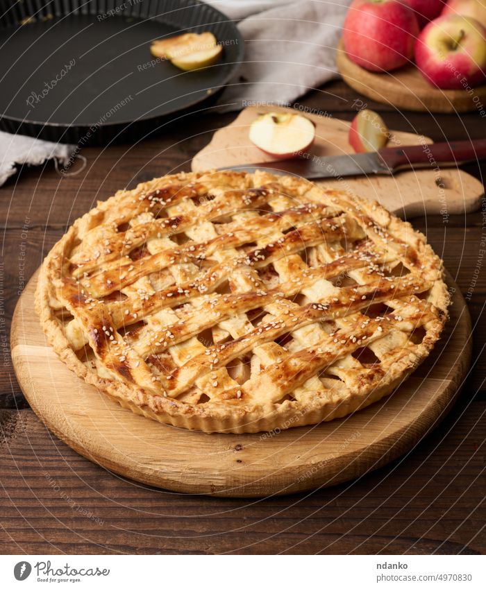 Round baked apple pie on a brown wooden table, top view round rustic food fresh fruit tart thanksgiving homemade meal napkin nutrition pastry seasonal sugar