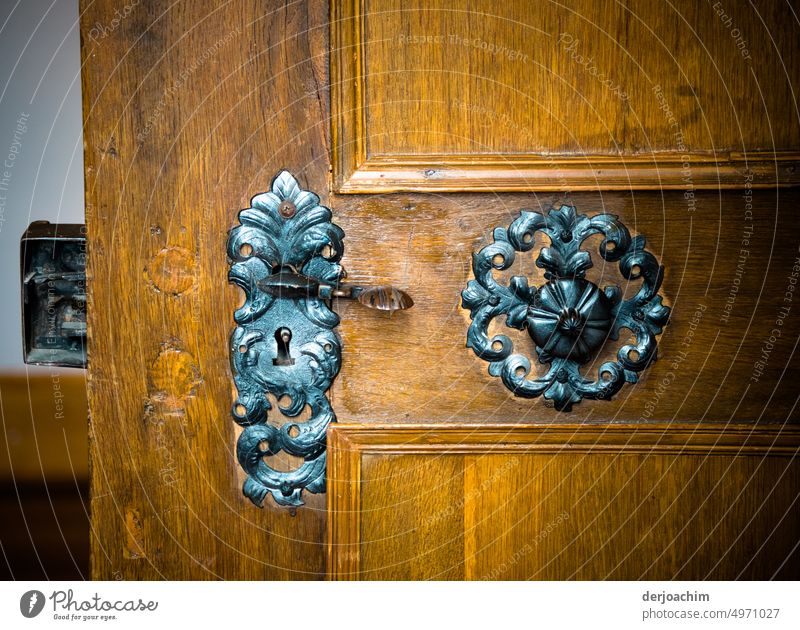 An old hand forged door lock on an oak door in a lock. Door lock Door handle Old Deserted Detail Colour photo Lock Front door Safety Wood Close-up Metal