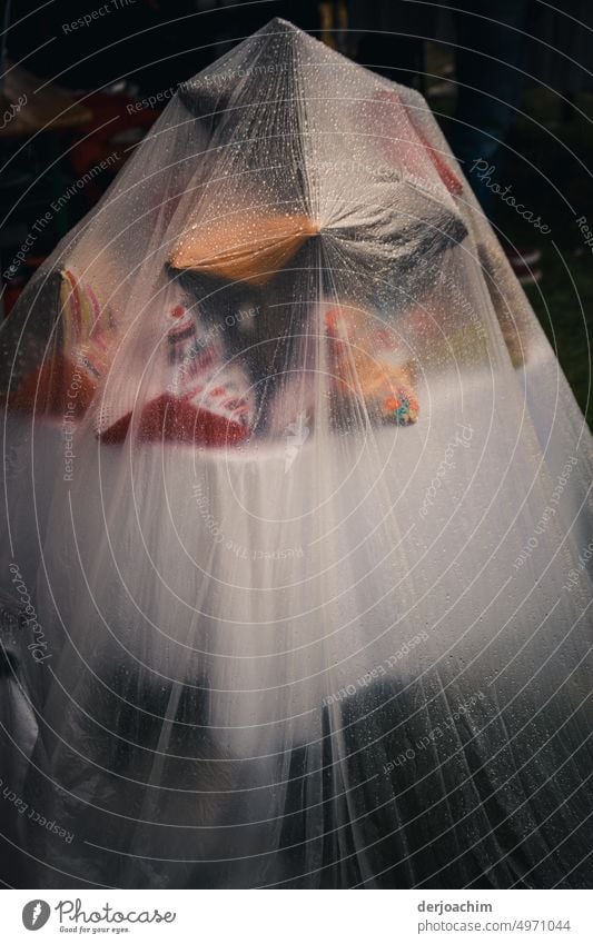 The sales table is covered by a foil.  The raindrops roll off the foil. Foil bag hard-wearing tear-resistant Safety Cloth Close-up Deserted Colour photo Detail